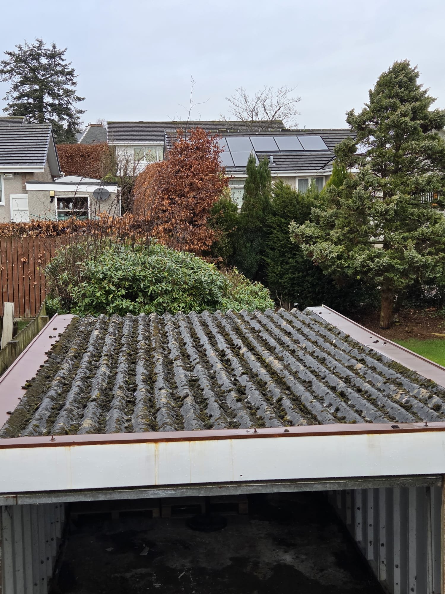 Original corrugated asbestos garage roof with visible moss before replacement