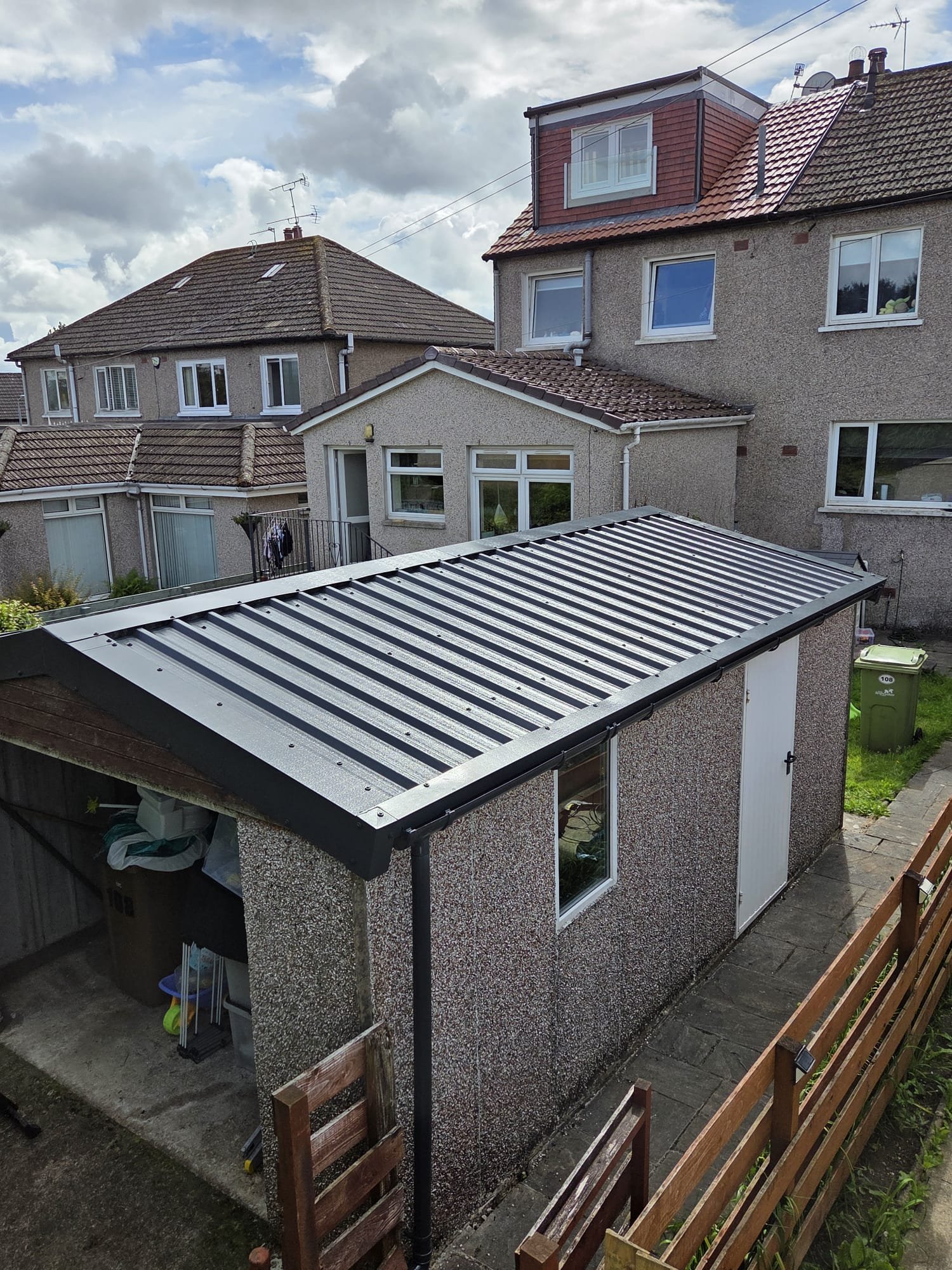 Completed grey pitched garage roof with dark ridge and edge trims